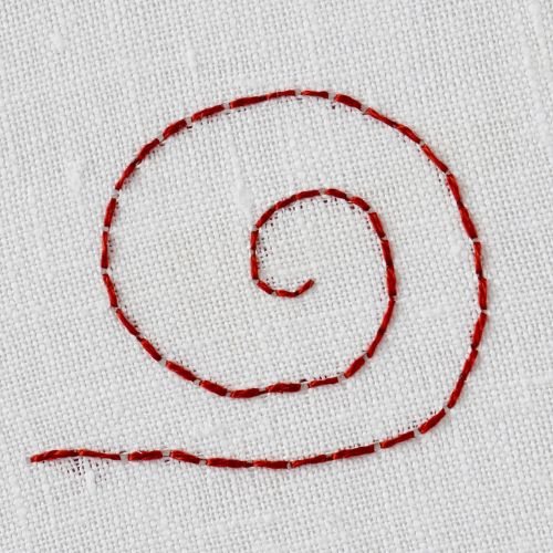 Broderie au point arrière dans un cercle en fil rouge foncé sur un tissu blanc