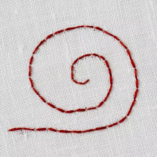 Broderie au point arrière dans un cercle en fil rouge foncé sur un tissu blanc