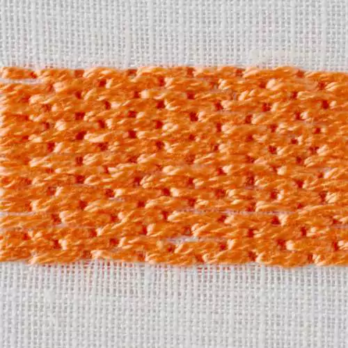 Broderie brick stitch avec coton perle orange sur tissu blanc