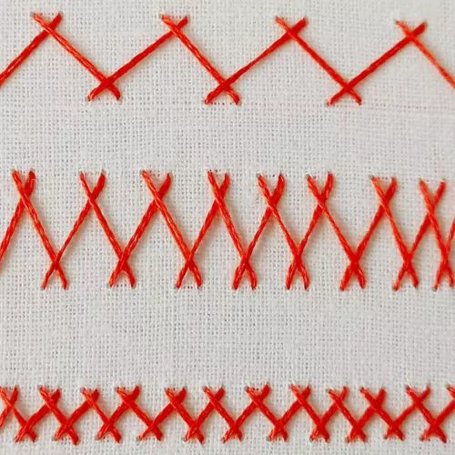 Broderie au point de chevrons avec fil rouge sur tissu blanc