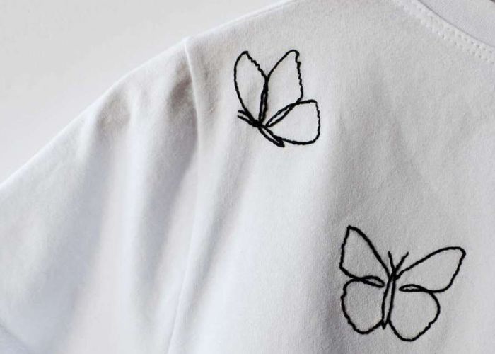 Blog de broderie pratique et école en ligne : image contour papillon noir sur t-shirt blanc juste sur blog brodeur pratique et école en ligne