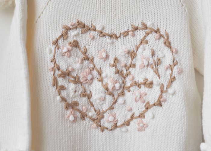 Pull blanc avec broderie fleurie en forme de cœur