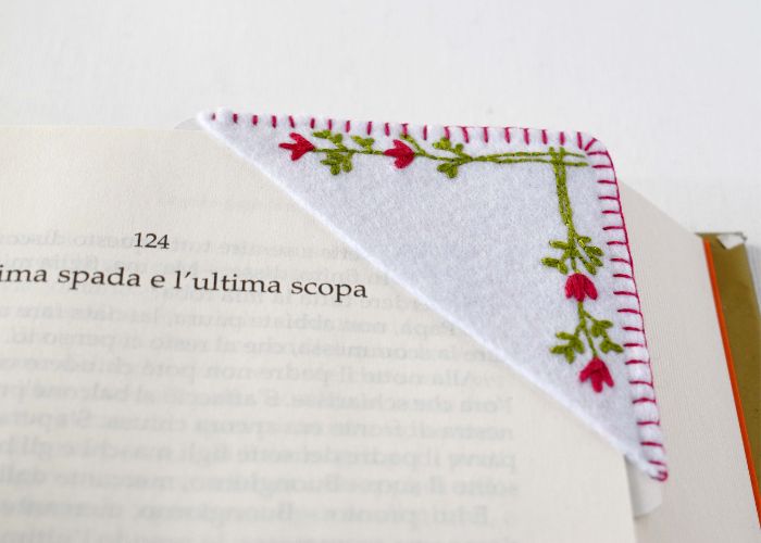 Signet d'angle brodé à la main avec des fleurs minimalistes placé sur un livre